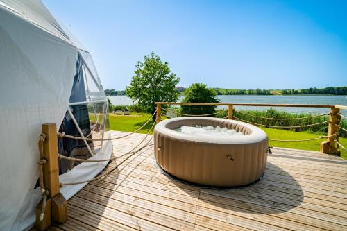 - un bain à remous installé sur une terrasse à côté d'un bateau dans l'établissement Lake Glamp Mikołajki - Adults Only, à Mikołajki