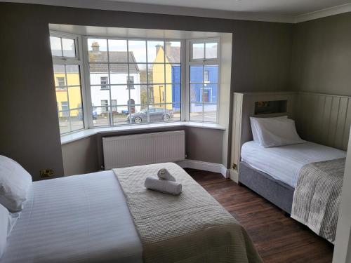 a small bedroom with two beds and a window at Urban Nest Townhouse in Galway