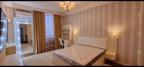1 dormitorio con cama y lámpara de araña en Khujand en Khujand