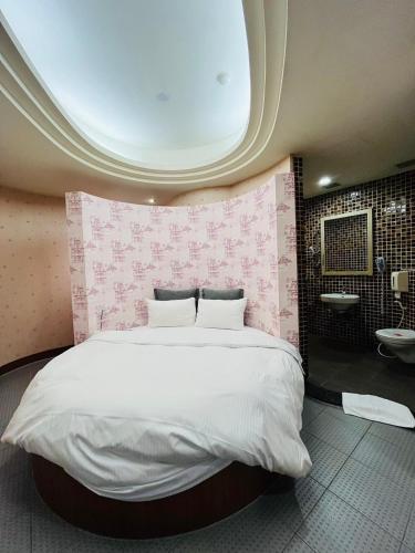 a bedroom with a large bed and a bathroom at Walker Hotel - Chengde in Taipei