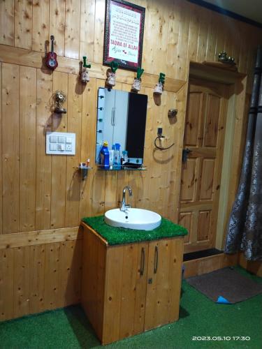 シュリーナガルにあるMoonlight Homestay Gulmargの木製の部屋のバスルーム(シンク付)
