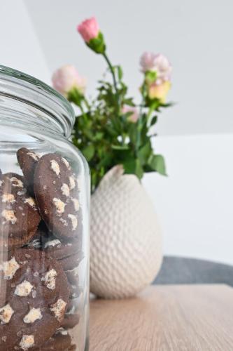 a glass jar filled with cookies and a vase with flowers at Šangulin Palace V in Biograd na Moru