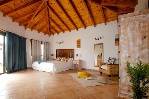 a bedroom with a bed and a couch in a room at casa verde in Lajares