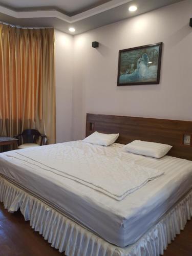 ein Schlafzimmer mit einem großen Bett mit weißer Bettwäsche in der Unterkunft Hotel ĐUC THANH VINH in Củ Chi