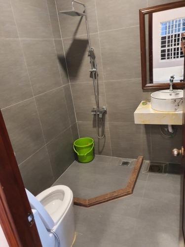 ein Bad mit einer Dusche, einem WC und einem Waschbecken in der Unterkunft Hotel ĐUC THANH VINH in Củ Chi