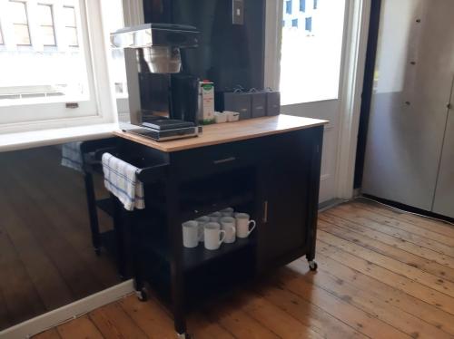 a coffee machine with mugs on top of it at Daddy Long Legs Art Hotel in Cape Town