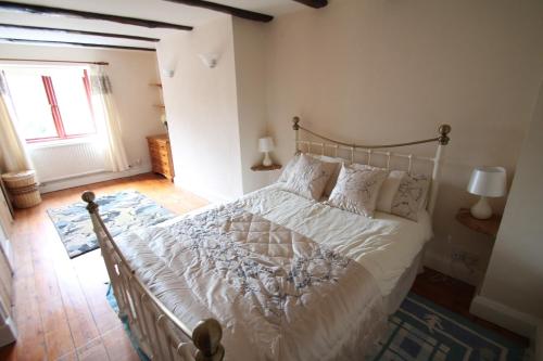 A bed or beds in a room at Priory Cottage 