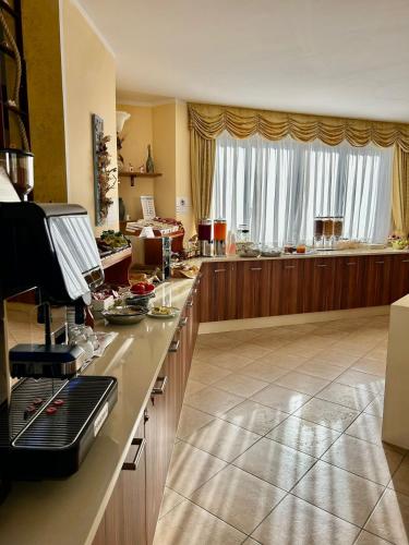 uma grande cozinha com um balcão e uma grande janela em Hotel L'Ancora em Capo Vaticano