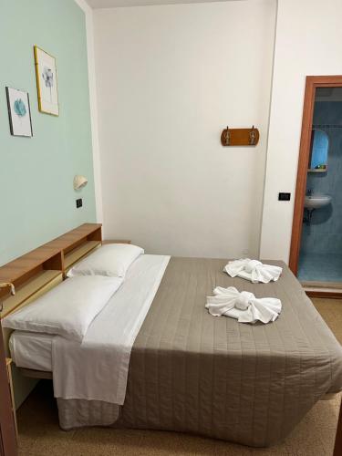 a bed in a bedroom with two towels on it at Hotel Enna Rimini in Rimini