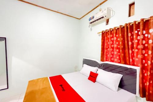 een slaapkamer met een bed met een rood gordijn bij RedDoorz Syariah near RS Bhayangkara Nganjuk in Nganjuk