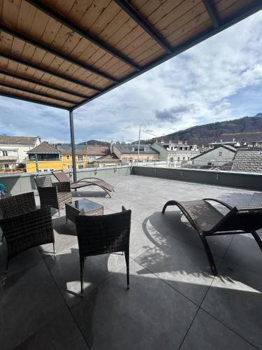 a patio with chairs and a table on a roof at CityLake G23 Apartments mit kostenloser Parkmöglichkeit !! in Gmunden