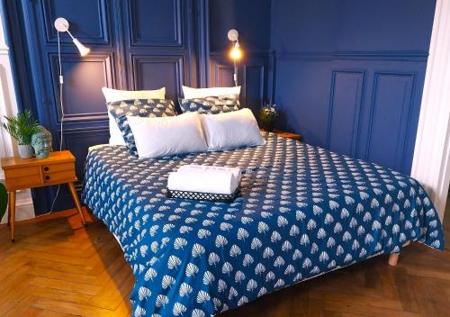 - une chambre bleue dotée d'un lit avec une couverture bleue et blanche dans l'établissement Le Carré Bleu - Studio Confort - Centre-ville, à Dieppe