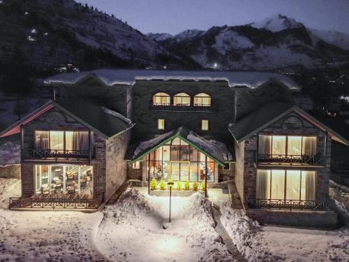 a house in the snow at night at Nivasana Manali - A Luxury Boutique Hotel in Manāli