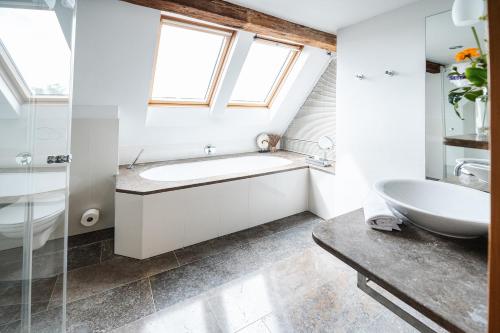 uma casa de banho com um lavatório, uma banheira e uma janela em Rebers Pflug em Schwäbisch Hall
