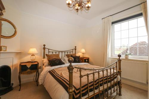 a bedroom with a bed and a window and a chandelier at The Coach House in Haywards Heath