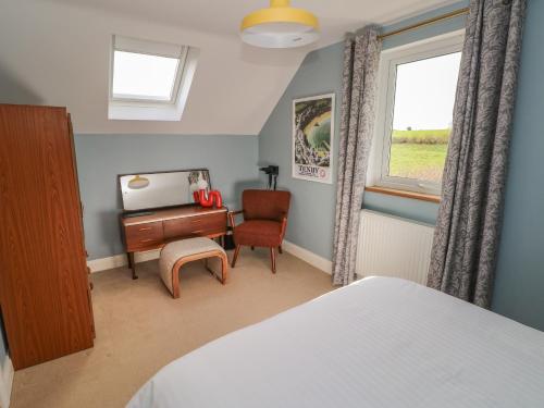 a bedroom with a bed and a desk and a window at The Annexe, Meadow Croft in Haverfordwest