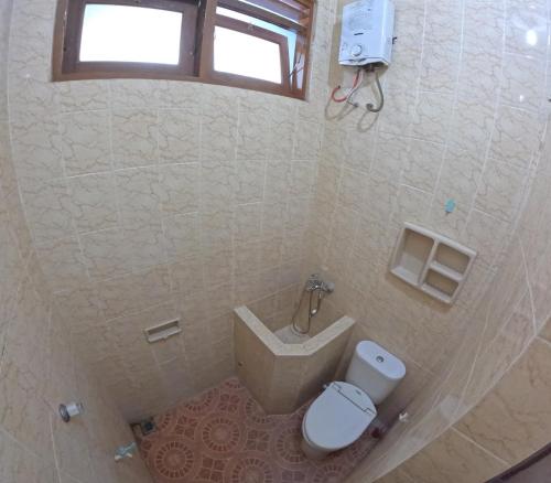 a small bathroom with a toilet and a sink at Griya Sinduadi Homestay Jogja in Jetis