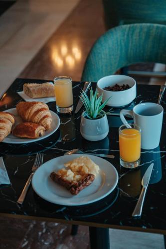 a table topped with plates of breakfast foods and drinks at Hôtel Le Royal Promenade des Anglais in Nice