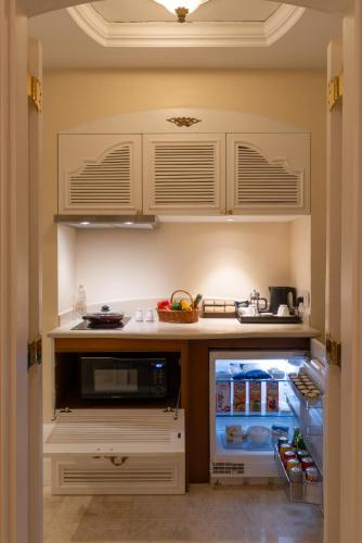 a kitchen with an open refrigerator filled with food at The Leela Palace Bengaluru in Bengaluru