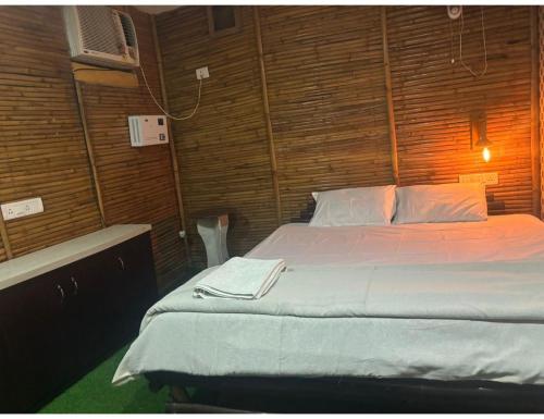 ein Schlafzimmer mit einem Bett in einer Holzwand in der Unterkunft Limewood Resort & Restaurant, Kushinagar in Kushinagar