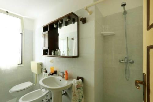 La salle de bains est pourvue d'une douche et de 2 lavabos blancs. dans l'établissement Corte Antica 3, à Presicce