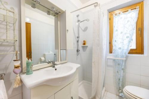 a white bathroom with a sink and a shower at La Margherita alla Zanca - Goelba in Zanca