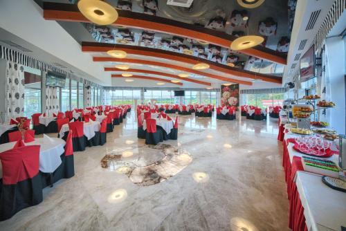 a banquet hall with red and black tables and chairs at Aquapark Health Resort & Medical SPA Panorama Morska All Inclusive in Jarosławiec