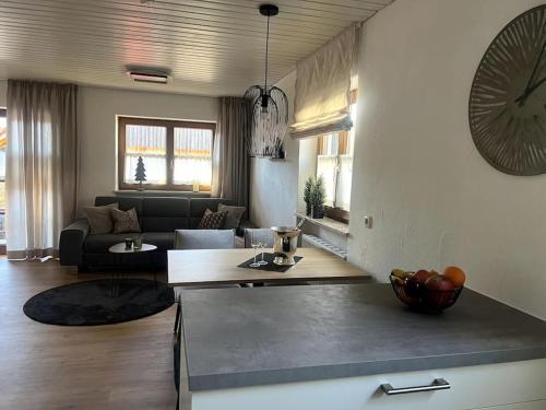 eine Küche und ein Wohnzimmer mit einem Sofa und einer Uhr in der Unterkunft Urlaub im Sonnendorf Burgberg in Burgberg