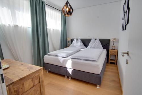 a bedroom with a bed with white sheets at Ferienwohnung Angerer in Bad Mitterndorf