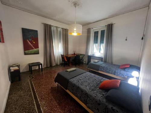 um quarto com duas camas e uma mesa em Ambra em Génova