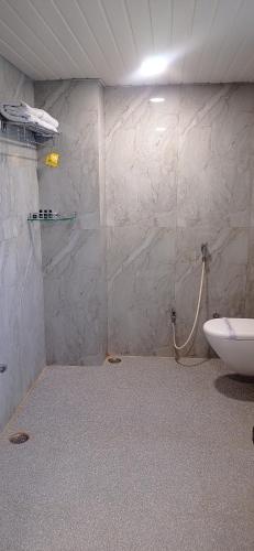 a bathroom with a shower and a toilet at Sun Stone Hotel & Club - Jawai in Sheoganj