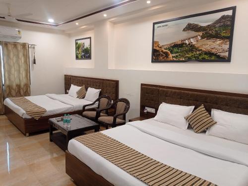 Habitación de hotel con 2 camas y mesa en Sun Stone Hotel & Club - Jawai en Sheoganj