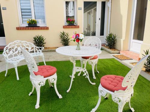 a group of chairs and a table on a lawn at Le Jardin des Plantes Rouen Studios et F2 au calmes, Terrasse, stationnement gratuit in Rouen