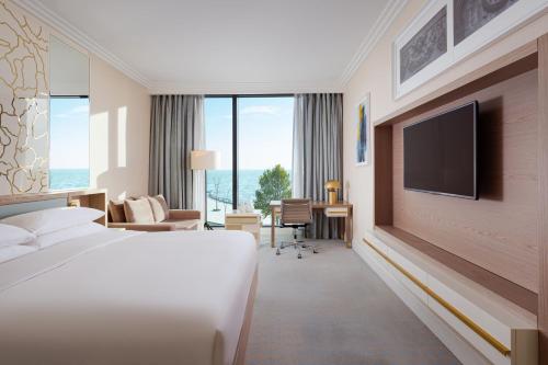 a hotel room with a bed and a flat screen tv at Baku Marriott Hotel Boulevard in Baku