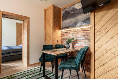 a dining room with a table and green chairs at Kosodrzewina in Zakopane