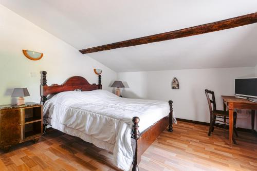 a bedroom with a large bed and a desk at L' Aixoise in Romegoux