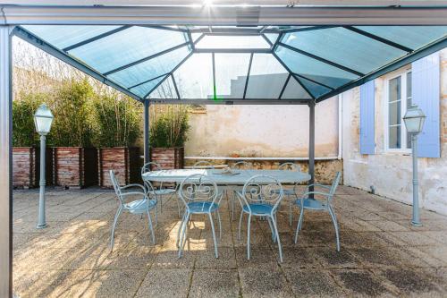 a patio with a table and chairs under a tent at L' Aixoise in Romegoux