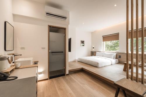 um quarto com uma cama, uma secretária e uma janela em 河映宿沐 River Trees Hotel em Kaohsiung
