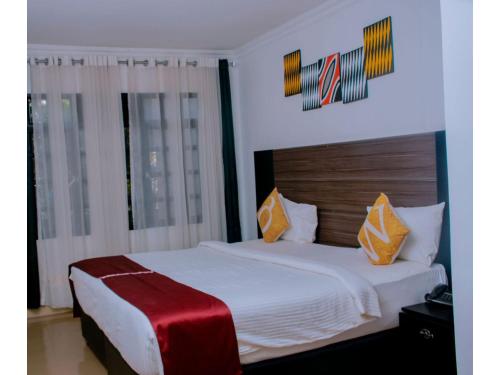 sypialnia z białym łóżkiem i czerwonym kocem w obiekcie Boutique Hotel Rwanda w mieście Kigali