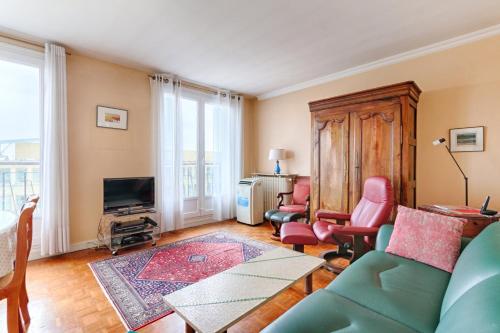 un salon avec un canapé, des chaises et une télévision dans l'établissement Résidor- Spacieux appartement Vincennes, à Vincennes