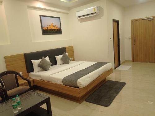 a bedroom with a bed and a chair at Sun Stone Hotel & Club - Jawai in Sheoganj