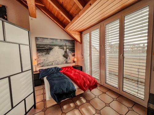 a bedroom with a bed in a room with windows at Dachwohnung in Flughafennähe in Kloten