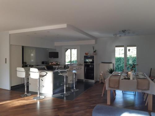 une cuisine et un salon avec une table et des chaises dans l'établissement KERJEANNE, à Cailloux-sur-Fontaines