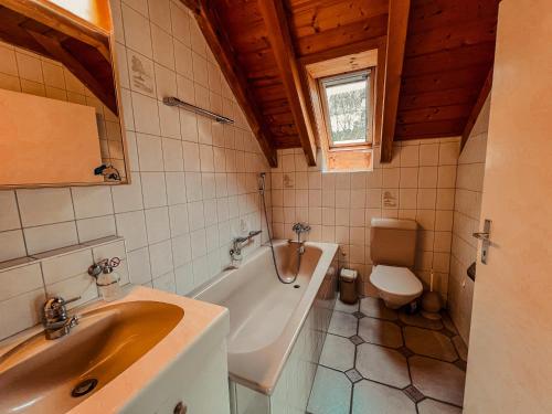 La salle de bains est pourvue d'un lavabo, d'une baignoire et de toilettes. dans l'établissement Dachwohnung in Flughafennähe, à Kloten