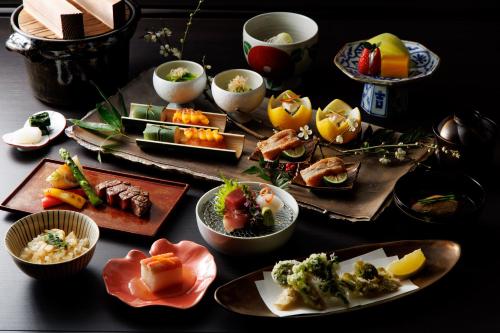 uma mesa com pratos e tigelas de comida em Shoraiso em Yamanouchi