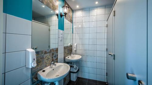 a bathroom with two sinks and a toilet at The Little Havana Party Hostel in Kraków