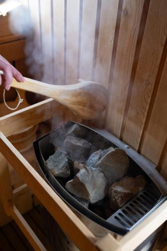 a person cooking food on a grill with a wooden spoon at Resort Bali Spa in Cornu de Jos