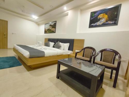 a bedroom with a bed and a table and a chair at Sun Stone Hotel & Club - Jawai in Sheoganj