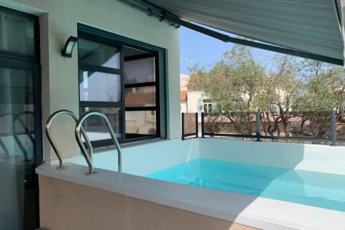 - une piscine dans une maison avec fenêtre dans l'établissement Villa Camarguaise entre Plage et centre ville avec bassin extérieur, au Grau-du-Roi