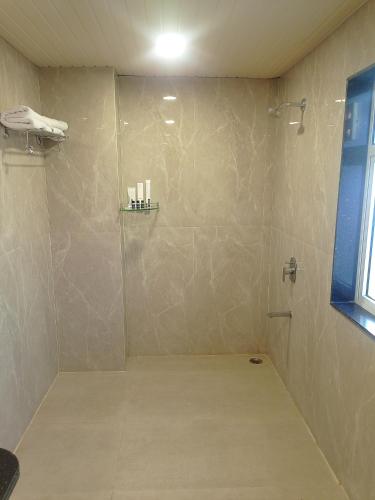 a bathroom with a shower with a glass door at Sun Stone Hotel & Club - Jawai in Sheoganj